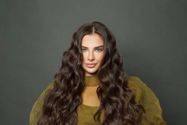 Saç bakımı ve güzellik konsepti. Siyah arka planda uzun dalgalı saçları olan neşeli esmer kadın.