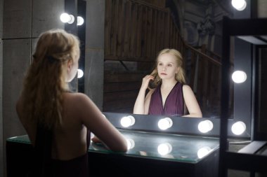 Young beautiful woman with makeup and reflection in dressing room