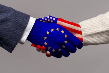 Avrupa Birliği ve ABD konsepti. Gri arkaplanda el sıkışmada bayraklar