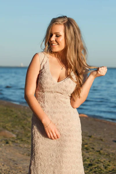 Happy model woman in prom dress outdoors