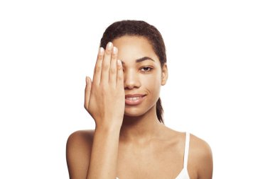 Sevimli Afro-Amerikan kadın gülümseyen ve elini yüzüne yakın tutan beyaz arka planda izole edilmiş.