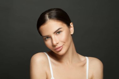 Siyah arka planda poz veren sağlıklı parlak ciltli mükemmel bir spa kadını.