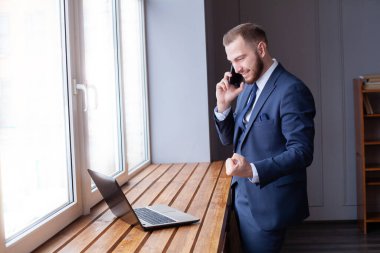 Akıllı telefon ve dizüstü bilgisayar kullanan iş adamı yöneticisi