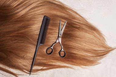 Sağlıklı, uzun kahverengi saçlar, profesyonel kuaför makası ve tarak. Saç stili ve saç tedavi geçmişi.