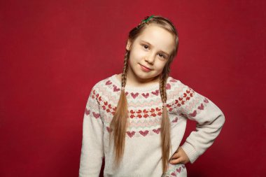 Sevimli, mutlu, gülümseyen, çekici, genç bir kız çocuğu kameraya bakıyor.