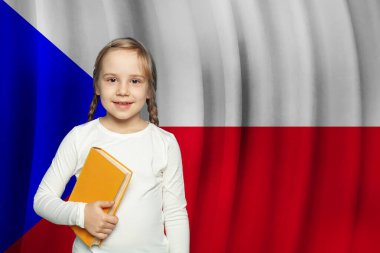 Küçük bir kız çocuğu gülümsüyor ve Çek bayrağına karşı bir kitap tutuyor. Çek Cumhuriyeti konseptinde eğitim ve okul