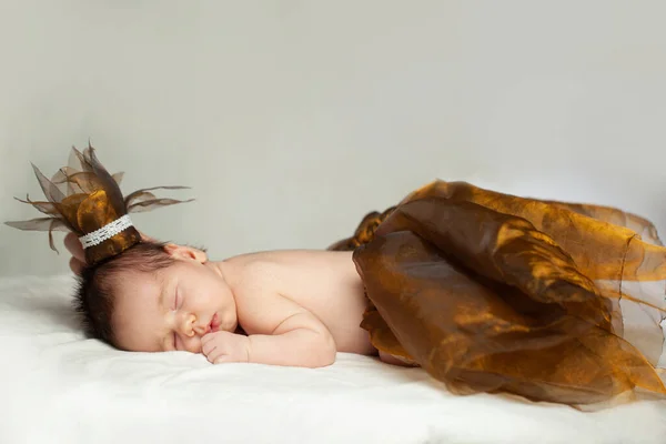 Sleeping newborn baby princess on white blanket
