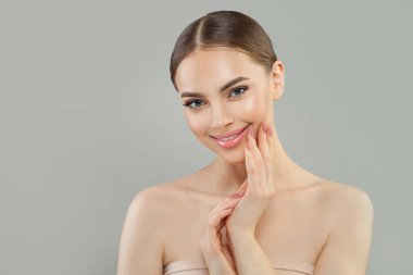 Gülümseyen, sağlıklı ciltli, mutlu, çekici genç bir kadın. Yüz bakımı, cilt bakımı ve spa konsepti