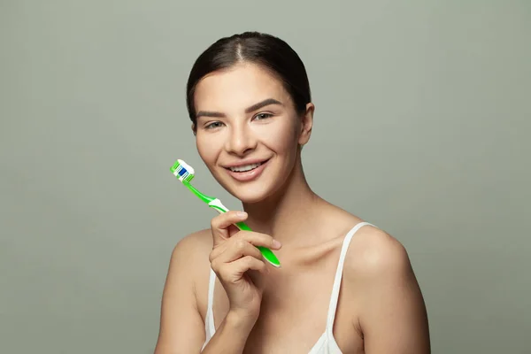 Happy joyful funny young woman brushes teeth with toothbrush, cares of oral hygiene concept
