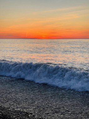 Gün doğumu ufku. Deniz dalgası ve renkli gökyüzü
