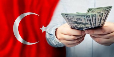 Ulusal Türk bayrağı ve Amerikan doları ellerinde. İş, vergi, bankacılık ve finans kavramı