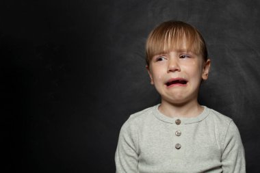 Genç kız depresyonda. Çocuk endişe içinde, kızgın ve korkmuş bir şekilde ağlıyor. Üzücü ifade.