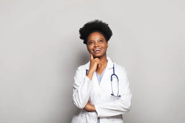 魅力的な黒女性医師でホワイト制服見上げます上のホワイトバナー背景 — ストック写真
