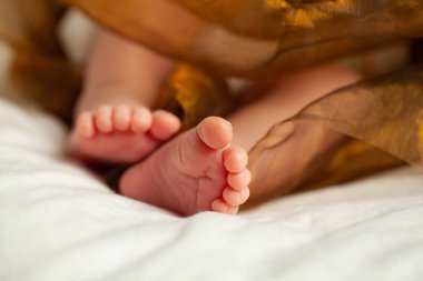 Yeni bebek ayağı beyaz arka plana yakın.