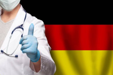 Alman doktorun eli Almanya bayrağında olumlu bir hareket sergiliyor.