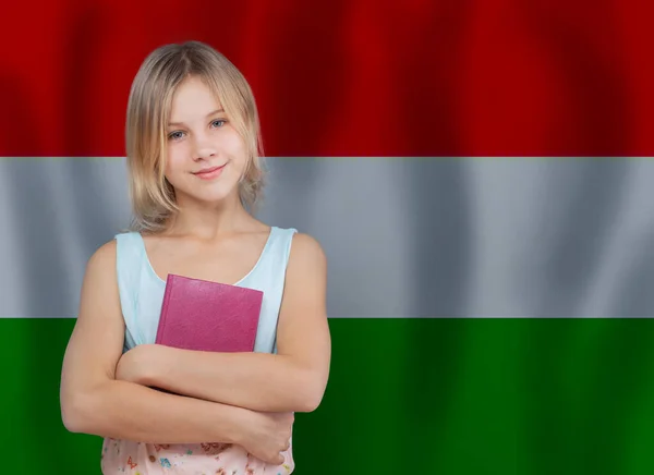 素敵な笑顔の女の子と本に対するハンガリー語のフラグの背景 — ストック写真