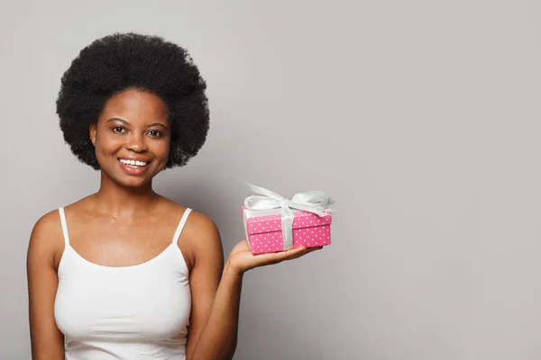 Portrait of smiling woman with pink present gift box on white background