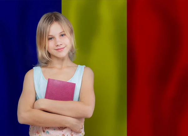 在罗马尼亚国旗的背景下 漂亮的少女学生微笑着 — 图库照片