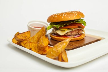 Beyaz arka planda ahşap tabakta sığır burger ve patates kızartması..