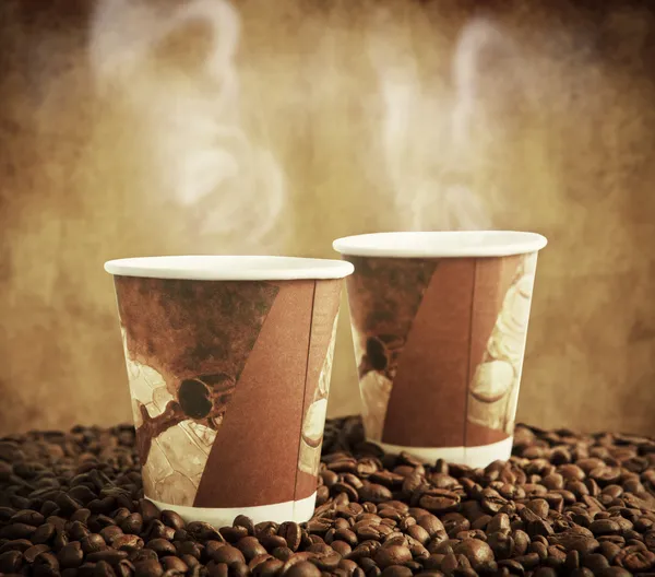 Paper cups with coffee beans — Stock Photo, Image