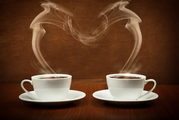 Heart shape by steaming cups of coffee — Stock Photo, Image