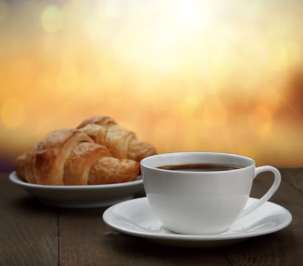 Morning breakfast - coffee and croissant in sunrise — Stock Photo, Image