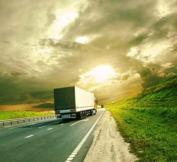 Lastbilar under färgglada himmel — Stockfoto