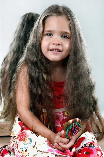 Menina com cabelo delicioso segurando escova de cabelo — Fotografia de Stock