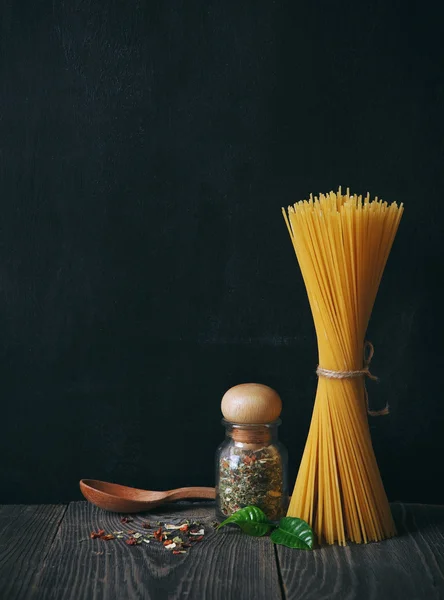 Spaghetti und Gewürze auf Tafel-Hintergrund. Kopierraum — Stockfoto