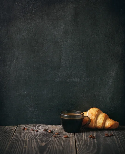 Café y croissant sobre fondo pizarra. espacio de copia —  Fotos de Stock