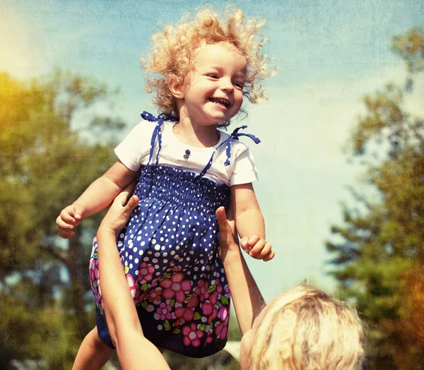 Little girl having fun with mother. vintage paper textured — Stock Photo, Image