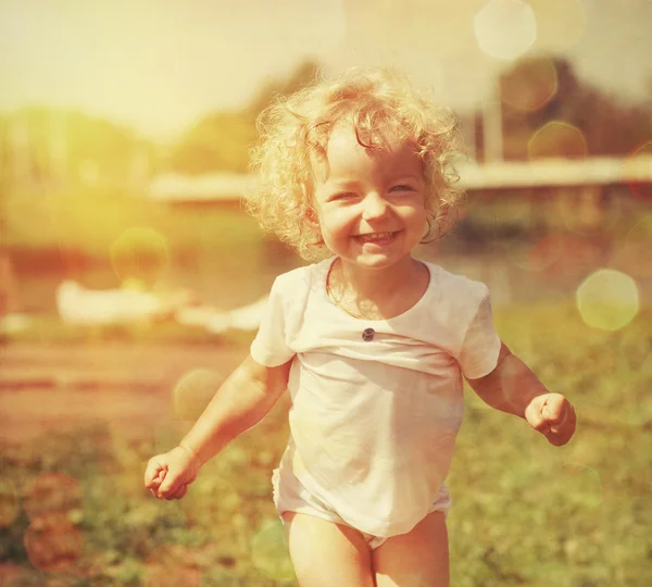 Šťastná holčička v letním slunci. vinobraní papír texturou — Stock fotografie