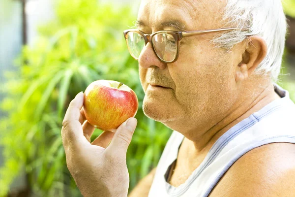 Old man eats apple — Stock Photo, Image