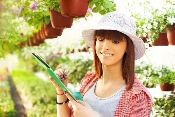 Fröhliche Floristin mit Blumen — Stockfoto