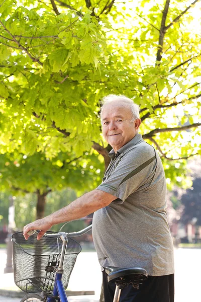Happy and smiling elderly man with bike — Stock Photo, Image