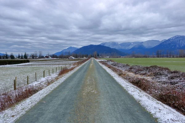 Dlouhá Rovná Cesta Rozděluje Venkovské Pastviny Vede Zimního Pohoří — Stock fotografie