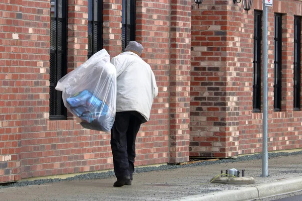 Bir Alkolik Kaldırımda Ağır Plastik Bir Torba Dolusu Bira Taşıyarak — Stok fotoğraf