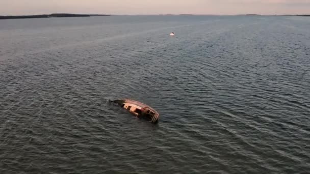 Drone Shot of Ocean and Small Boat Wreck in the Middle with Trees by the Shore — Video