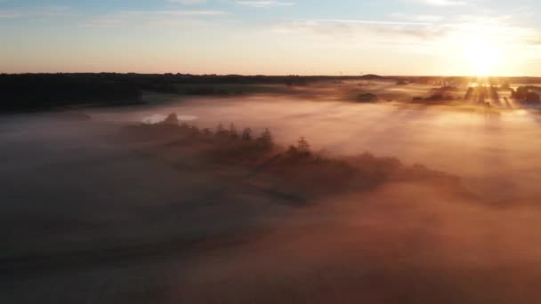 Vista aérea de los rayos de sol que brillan por encima del horizonte de niebla en Dinamarca — Vídeo de stock