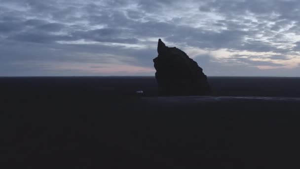 Silhueta de Arnardrangur Sea Stack em uma vista aérea no amanhecer na Islândia — Vídeo de Stock