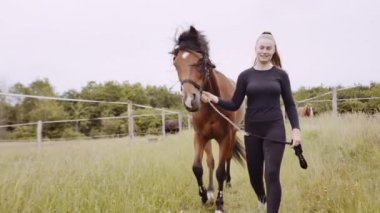 At Sürücüsü Genç Kadın Otların Arasında Yürüyor