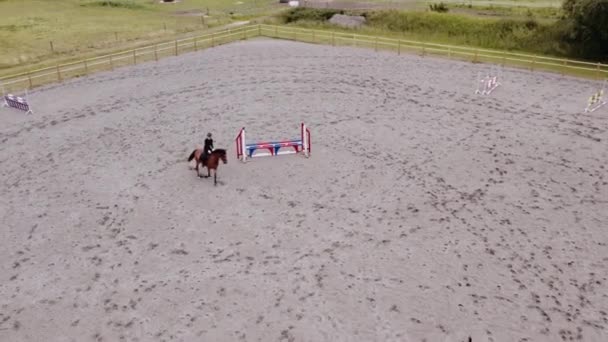 Drohne der Frau reitet Pferd durch Paddock — Stockvideo