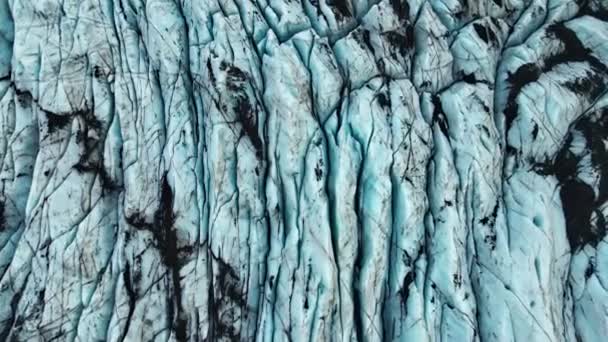 Drönare över spruckna svarta och blå yta av glaciär — Stockvideo