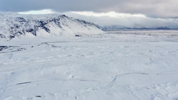 Drone sobre el paisaje cubierto de nieve hacia la montaña — Vídeos de Stock