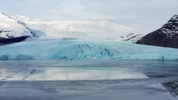 Drone hacia el glaciar entre montañas cubiertas de nieve — Vídeos de Stock