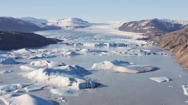 Szeroki lot dronem nad zamarzniętym jeziorem z lodowcem — Wideo stockowe