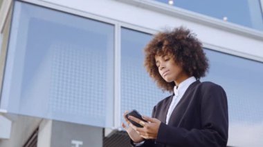 Ofis dışında akıllı telefon kullanan Afro İşkadını