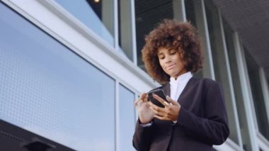 Ofis dışında akıllı telefon kullanan Afro İşkadını
