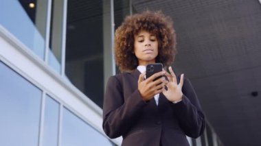 İş kadını Smartphone 'da ofis dışında mesajlaşıyor