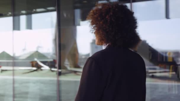 Mujer de negocios con cabello afro caminando fuera de la oficina moderna — Vídeos de Stock